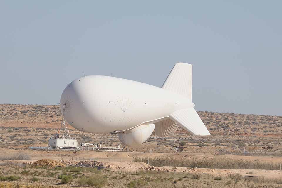 Big aerostat on the ground in a desertic landscape