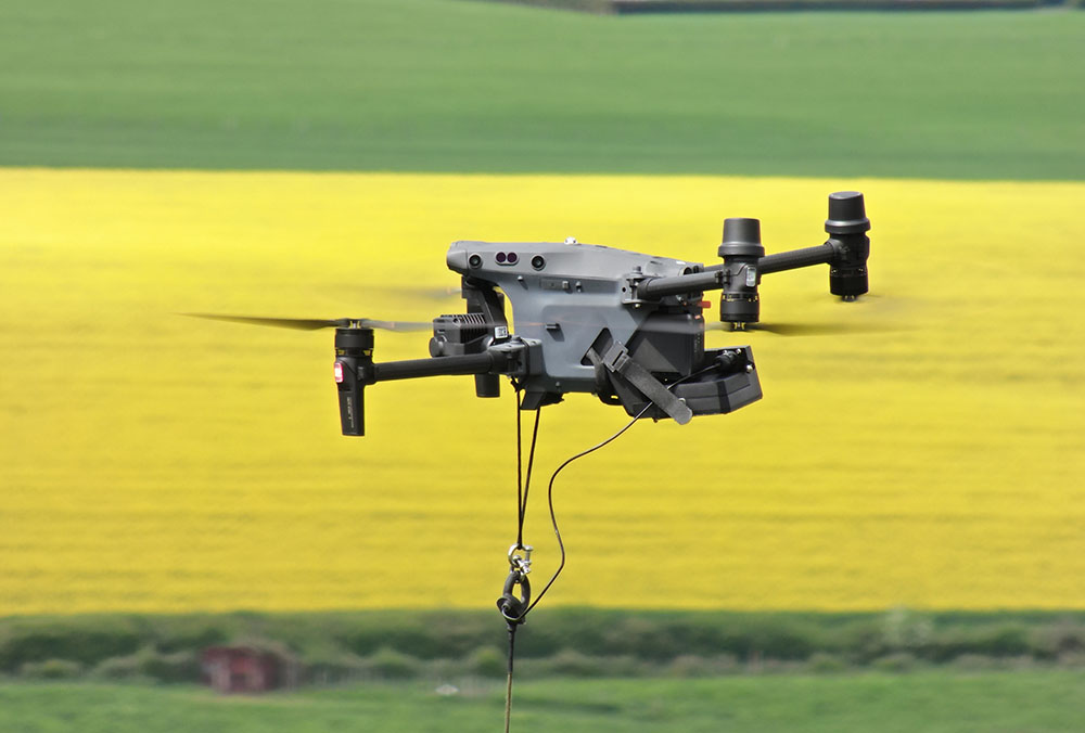 DJI M30 drone flying tethered with Elistair Air Module. Nice yellow rapeseed field in the background