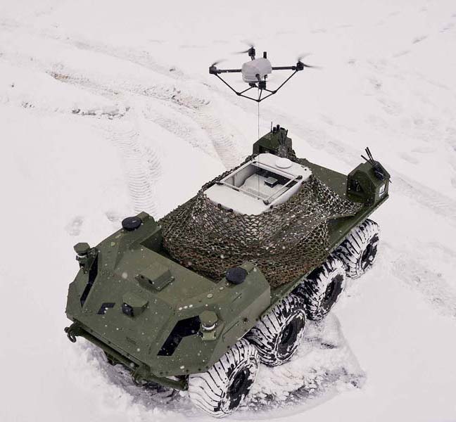 A military vehicle with a drone mounted on top, ready for reconnaissance and surveillance missions.