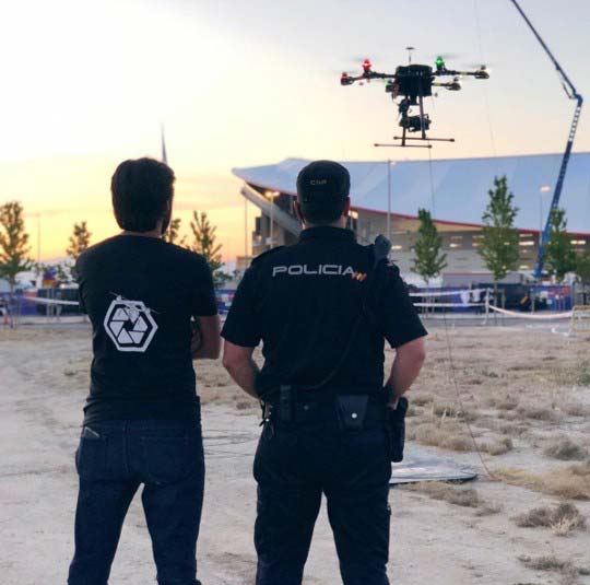 Police officer and technician monitoring a tethered drone during an event