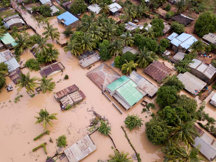 Aerial view of a flooded village with submerged houses and trees
