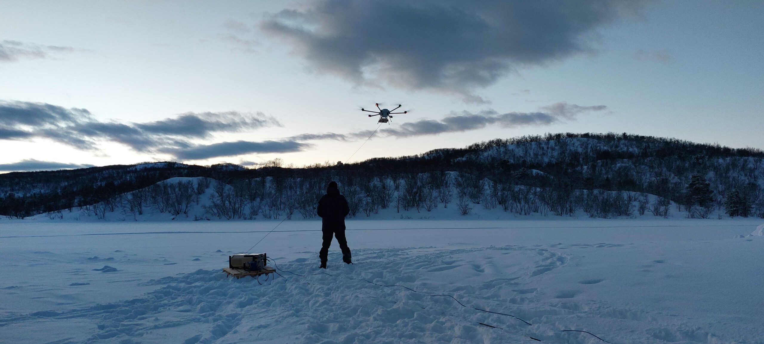 Tethered drone being operated in a snowy landscape