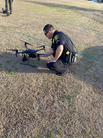 Police officer operating a drone for surveillance in an urban area