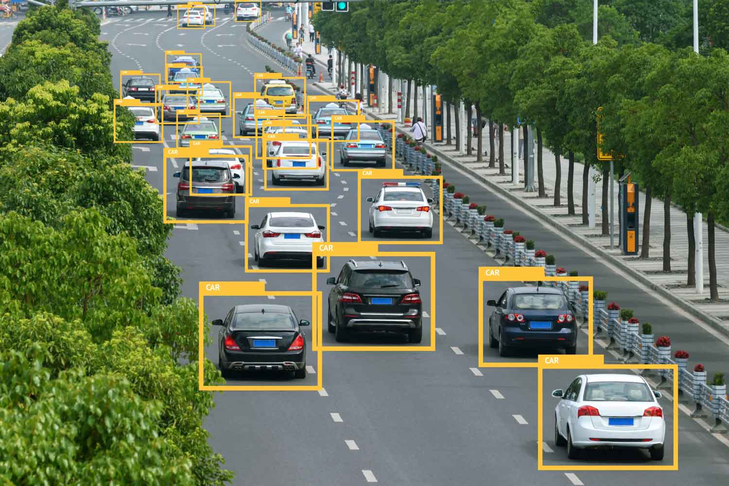 Overhead view of a busy street with multiple cars monitored by a drone, trees and pedestrians on the sidewalk