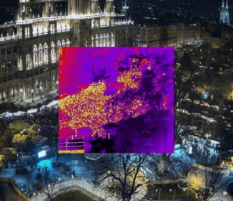 A drone monitors a crowd with a night vision camera during an event at night