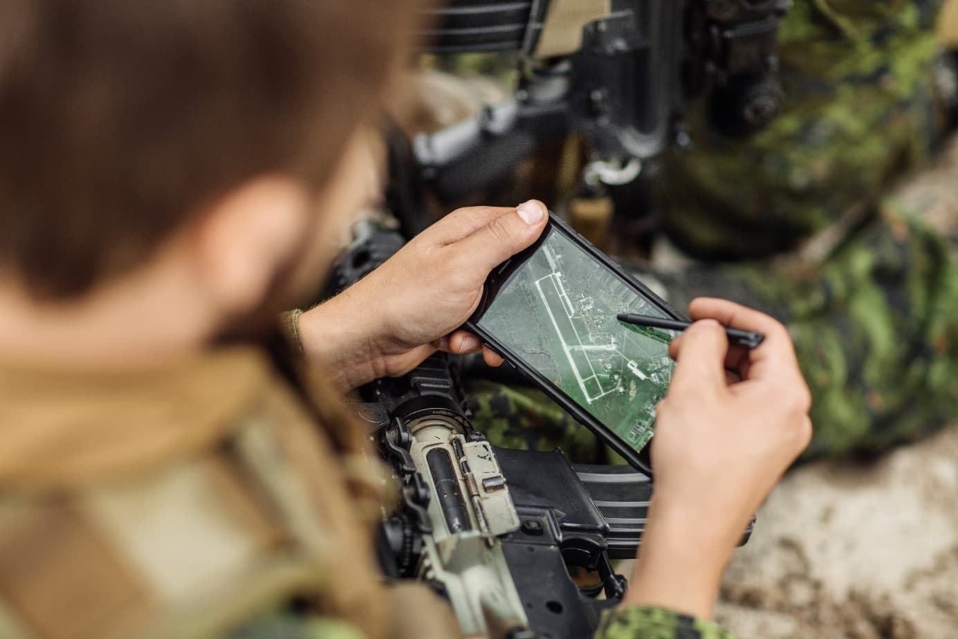 A soldier uses software on a tablet to steer a drone remotely